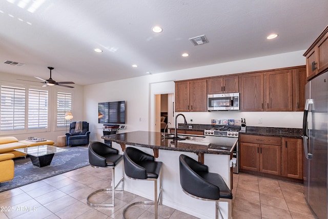 kitchen featuring stainless steel appliances, open floor plan, recessed lighting, and a sink