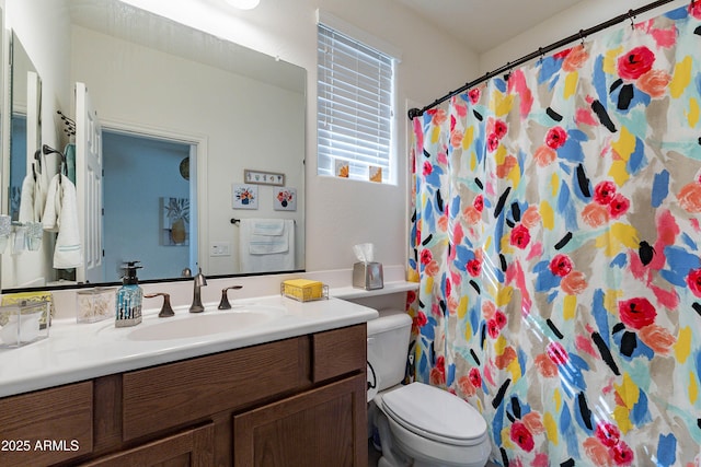 bathroom featuring toilet, a shower with shower curtain, and vanity