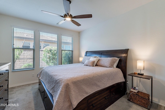 bedroom with baseboards, multiple windows, ceiling fan, and light carpet