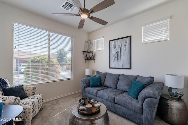 living area with ceiling fan, visible vents, baseboards, and carpet