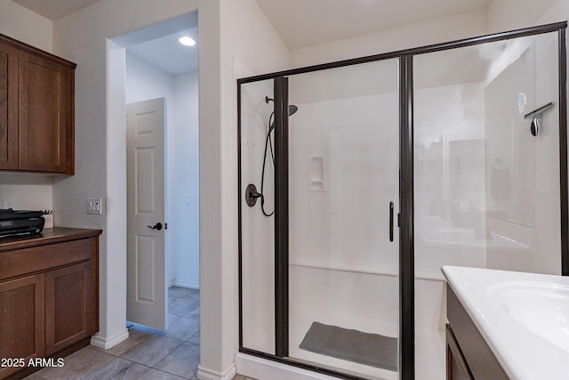 full bath featuring vanity, baseboards, a shower stall, and tile patterned floors