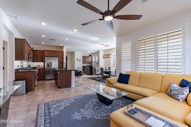 living area with a ceiling fan, visible vents, light tile patterned floors, and recessed lighting