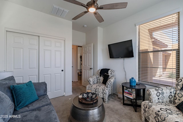 living room featuring carpet floors, a ceiling fan, and visible vents