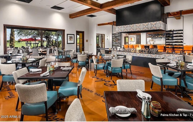 dining room with visible vents, a high ceiling, and beamed ceiling