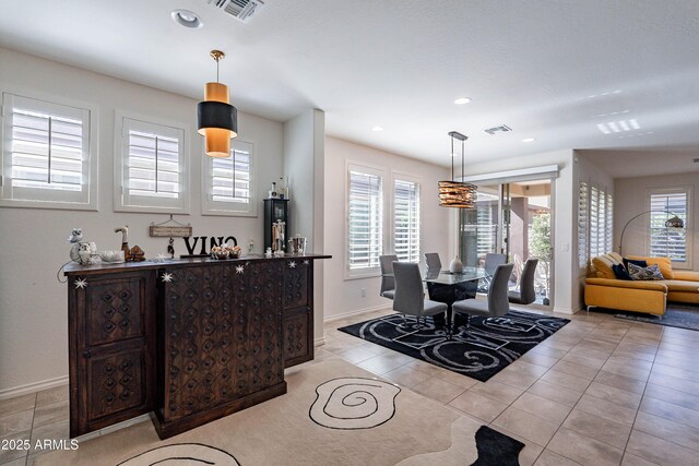 dining room featuring light tile patterned floors, baseboards, and visible vents