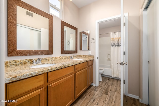 full bathroom with shower / bath combination with curtain, vanity, hardwood / wood-style floors, and toilet