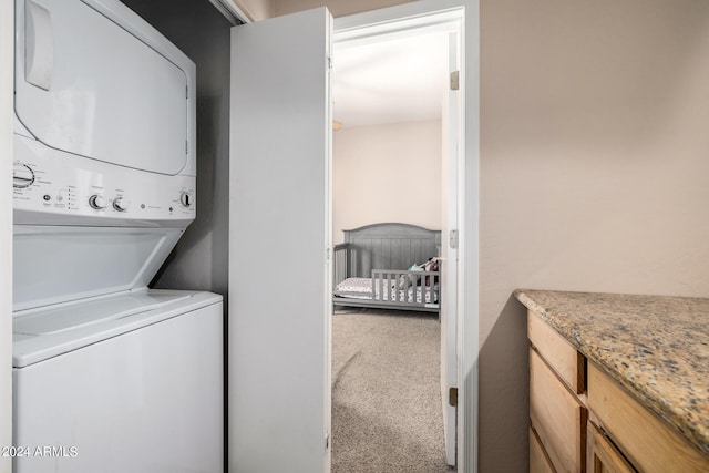 washroom featuring carpet floors and stacked washer and dryer