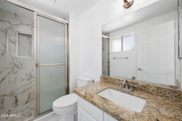 bathroom featuring walk in shower, vanity, and toilet