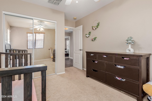 carpeted bedroom with ceiling fan and a closet