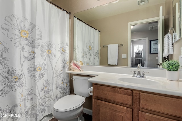 bathroom with walk in shower, vanity, and toilet