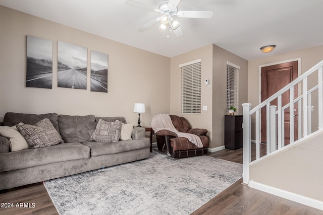 living room featuring dark wood-type flooring and ceiling fan