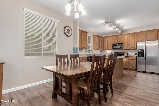 dining area featuring hardwood / wood-style flooring and an inviting chandelier