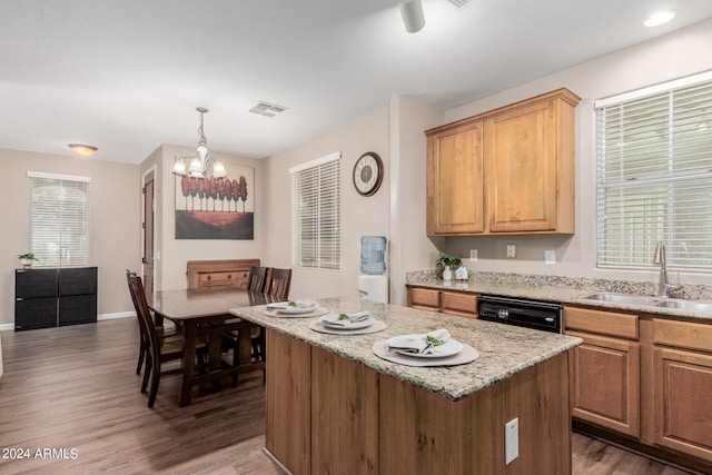 kitchen with sink, dark hardwood / wood-style floors, hanging light fixtures, a center island, and black dishwasher