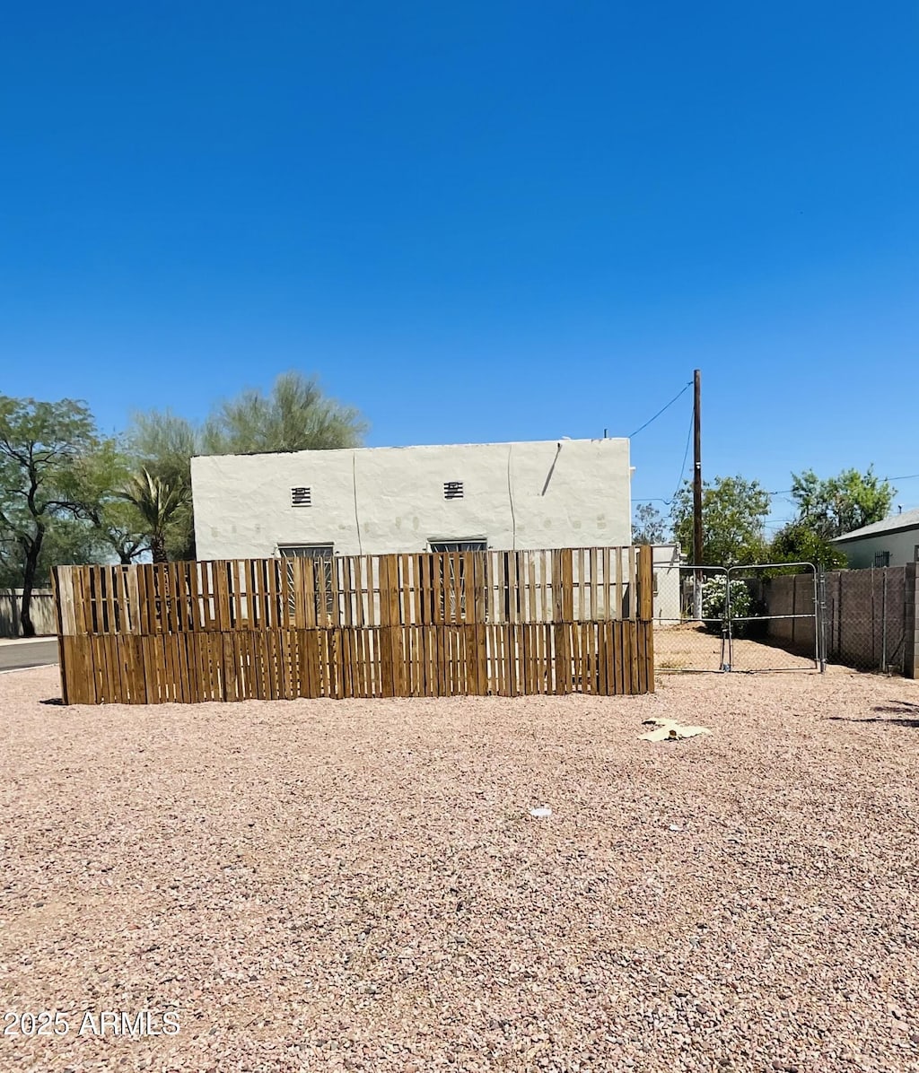 rear view of house featuring fence and stucco siding