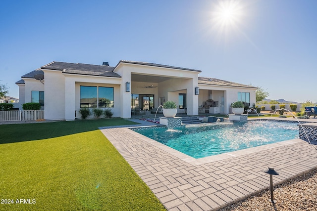 back of property with a patio, ceiling fan, pool water feature, and a lawn