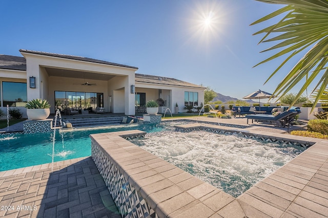 view of swimming pool with an outdoor living space, pool water feature, a patio, and ceiling fan