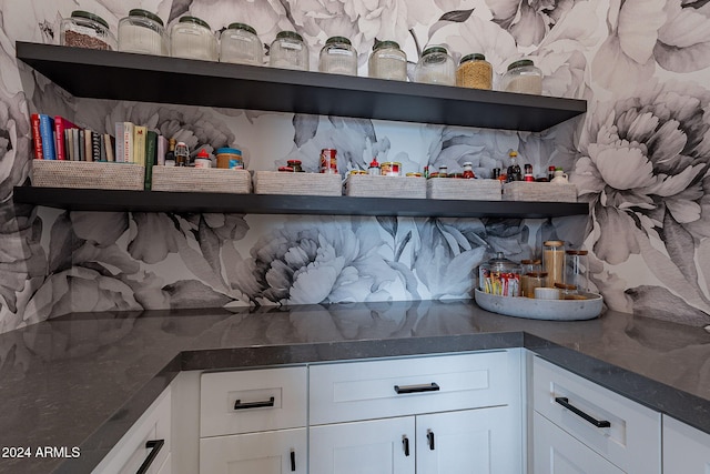 interior space with white cabinetry, tasteful backsplash, and dark stone counters