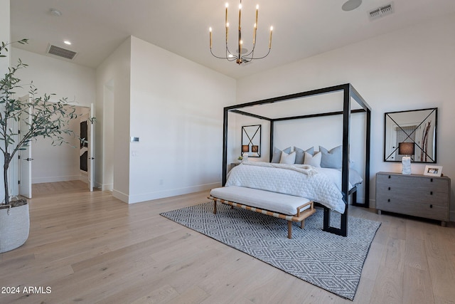 bedroom featuring light hardwood / wood-style flooring and a chandelier