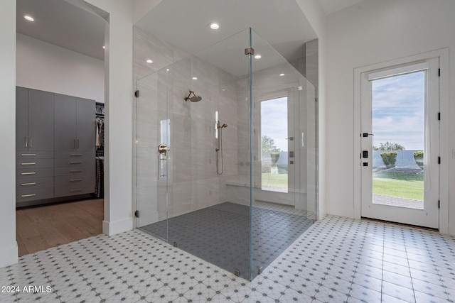 bathroom featuring a healthy amount of sunlight, wood-type flooring, and an enclosed shower