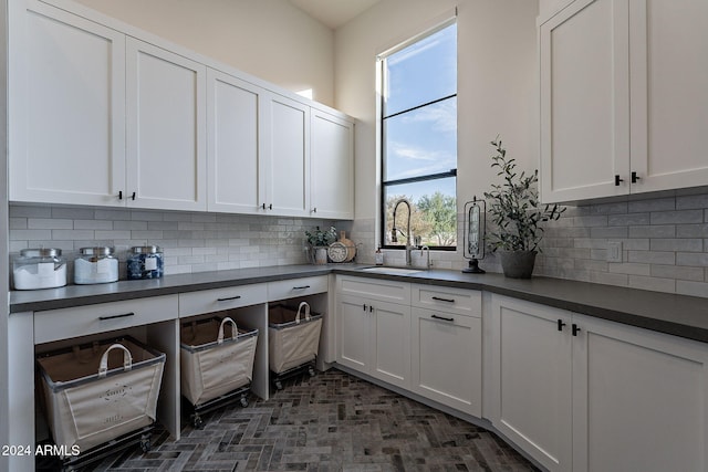 kitchen featuring sink, white cabinetry, and tasteful backsplash