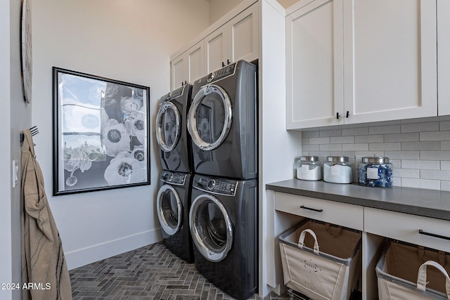 clothes washing area with cabinets and stacked washer and clothes dryer