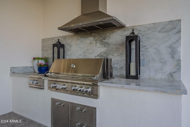 exterior space featuring backsplash, wall chimney exhaust hood, and dark brown cabinets