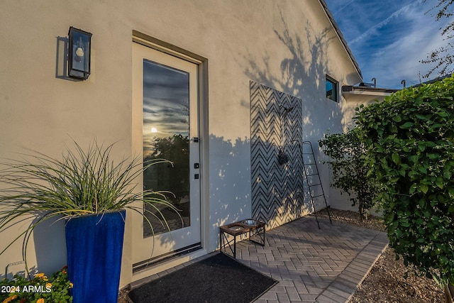 view of exterior entry with a patio