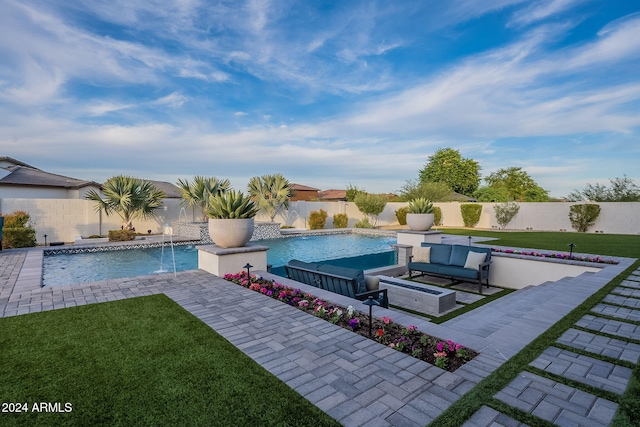 view of swimming pool featuring a patio area, pool water feature, a lawn, and an outdoor hangout area