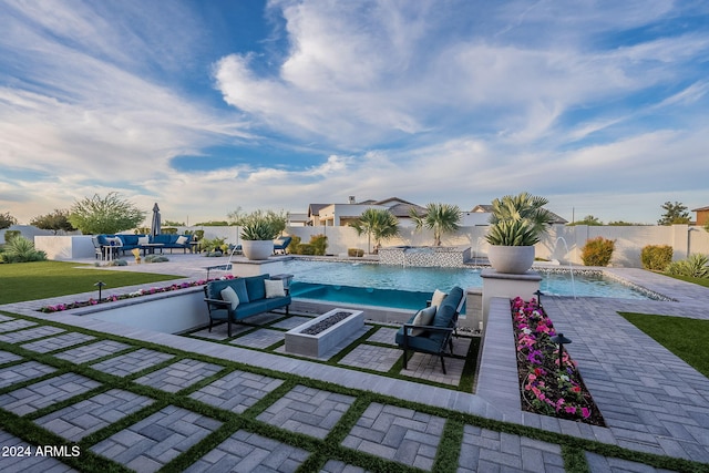 view of swimming pool featuring a patio, pool water feature, a lawn, and an outdoor fire pit