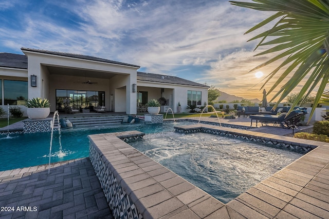 view of pool featuring a hot tub, pool water feature, and a patio area