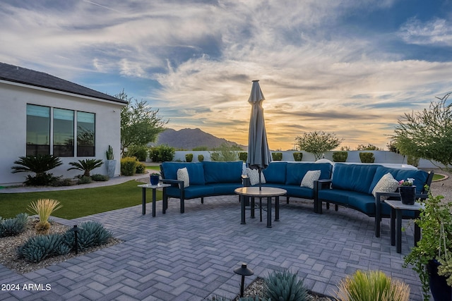 patio terrace at dusk with a mountain view and an outdoor hangout area