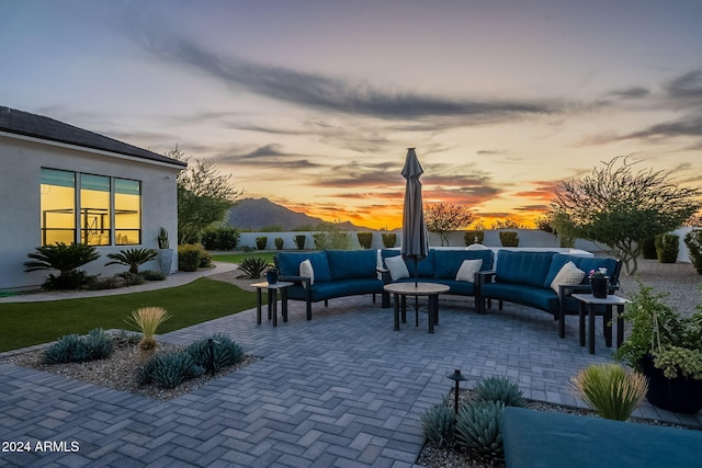 patio terrace at dusk with outdoor lounge area and a mountain view