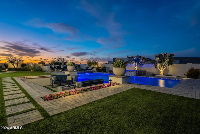 pool at dusk with a patio area, outdoor lounge area, pool water feature, and a lawn