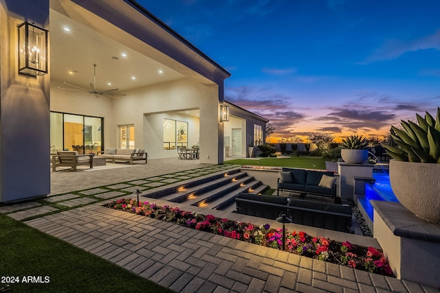 patio terrace at dusk with an outdoor living space and ceiling fan