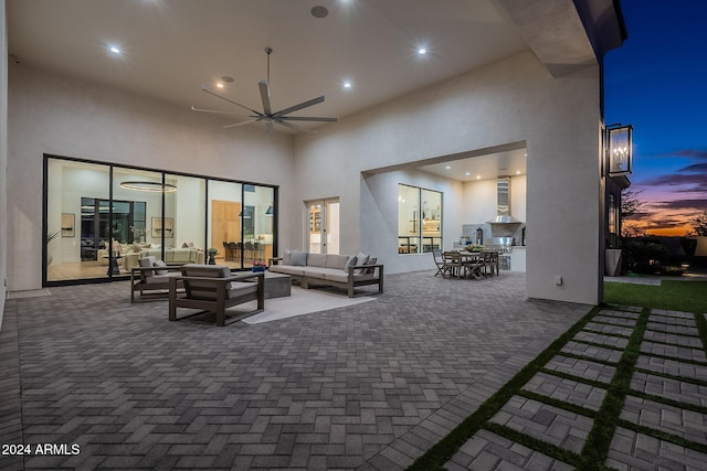 patio terrace at dusk featuring ceiling fan and outdoor lounge area