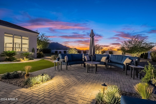 patio terrace at dusk with a lawn and an outdoor hangout area