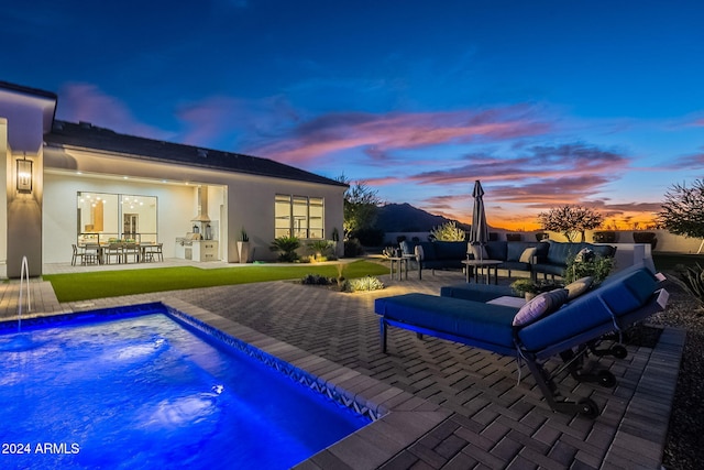 pool at dusk with a patio area