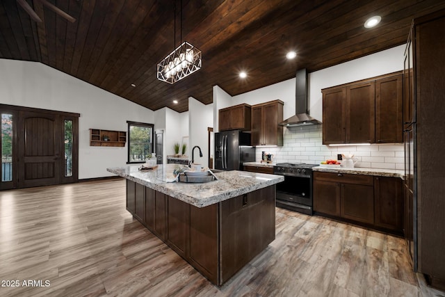 2702 Majestic Elk Rd, Overgaard, AZ 85933 - kitchen with stainless steel range with gas stovetop, light wood-type flooring, wall chimney range hood, black refrigerator with ice dispenser, and a sink