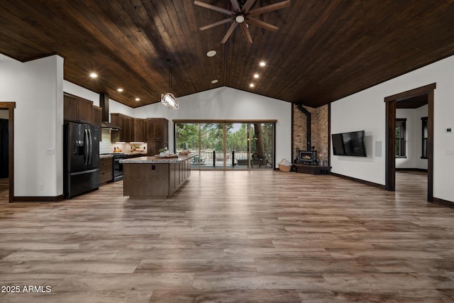 2702 Majestic Elk Rd, Overgaard, AZ 85933 - kitchen with black fridge, open floor plan, dark brown cabinets, wood finished floors, and gas range oven