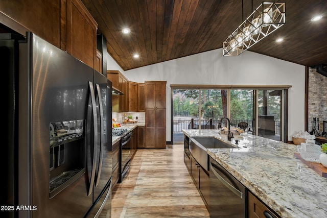 2702 Majestic Elk Rd, Overgaard, AZ 85933 - kitchen with light stone counters, black appliances, light wood-style floors, lofted ceiling, and a sink