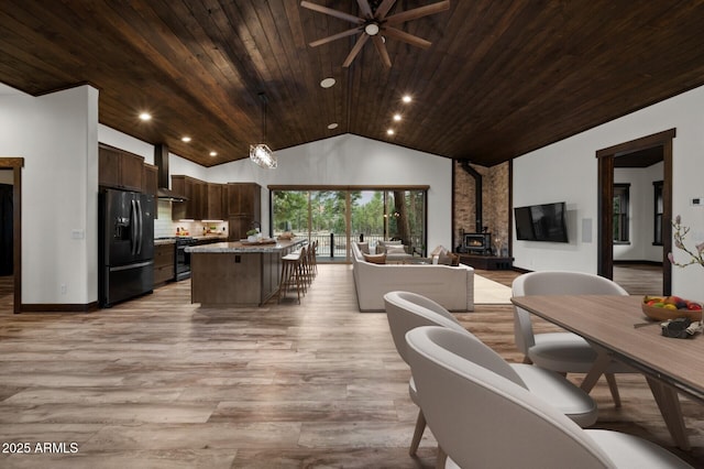 2702 Majestic Elk Rd, Overgaard, AZ 85933 - dining area with light wood-type flooring, vaulted ceiling, a ceiling fan, a wood stove, and wooden ceiling