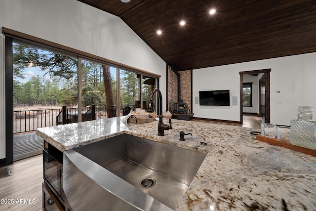 2702 Majestic Elk Rd, Overgaard, AZ 85933 - kitchen featuring wooden ceiling, a wood stove, light wood-style floors, high vaulted ceiling, and a sink