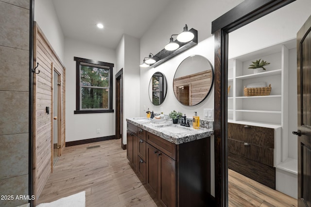 2702 Majestic Elk Rd, Overgaard, AZ 85933 - full bath with wood finished floors, double vanity, a sink, and baseboards