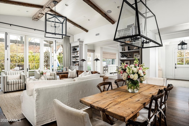 dining space featuring a healthy amount of sunlight, hardwood / wood-style flooring, visible vents, and beamed ceiling