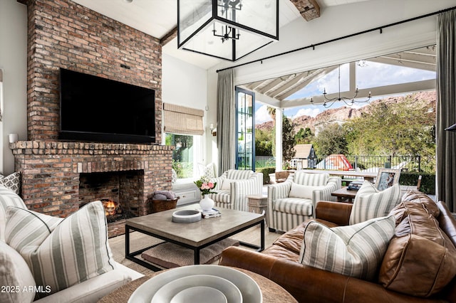 living room featuring vaulted ceiling with beams and a fireplace