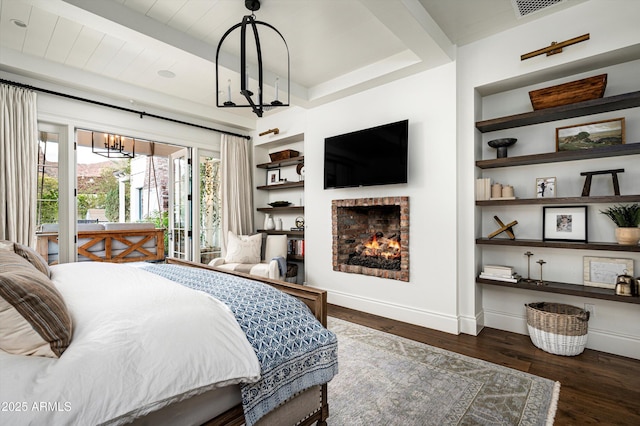 bedroom with access to exterior, a fireplace, a notable chandelier, wood finished floors, and baseboards