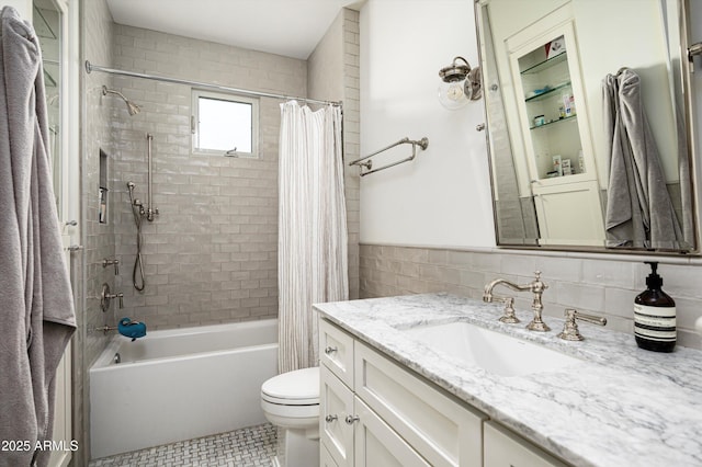 full bathroom with tile walls, vanity, toilet, and shower / bathtub combination with curtain