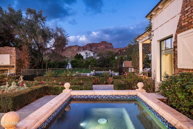 view of pool featuring fence and an in ground hot tub