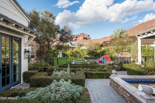 view of yard featuring fence, a mountain view, and a patio