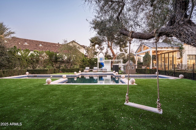 view of yard featuring a fenced backyard, a fenced in pool, and a playground